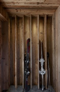 there are skis and snowboards in the corner of this wooden room that is being built