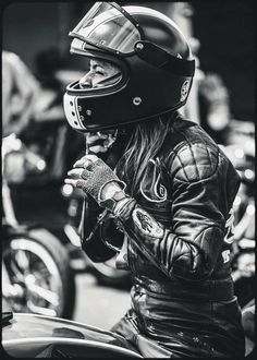 a black and white photo of a person wearing a motorcycle helmet