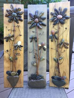 three wooden plaques with flowers and stones on them