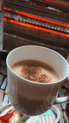 a cup of coffee sitting on top of a saucer next to a toaster oven