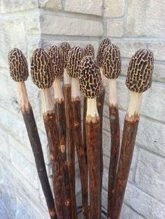 five wooden sticks with brown and white designs on them sitting in front of a brick wall