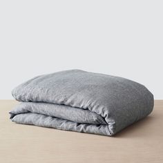 two gray pillows on top of a wooden table