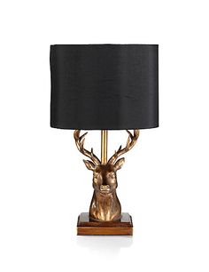 a gold deer lamp with a black shade on it's head and antlers