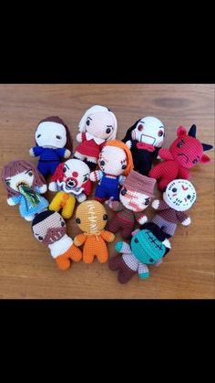 a group of small knitted dolls sitting on top of a wooden table next to each other