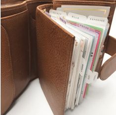 a brown leather purse with several folders in it