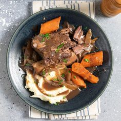 a blue plate topped with meat and mashed potatoes