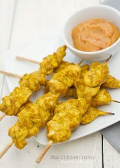 chicken skewers with dipping sauce on the side