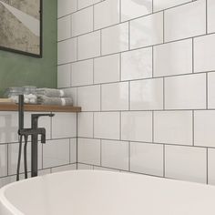 a white bath tub sitting next to a wooden shelf