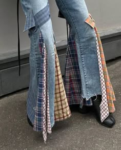 a pair of jeans with ties tied to them are standing in front of a wall