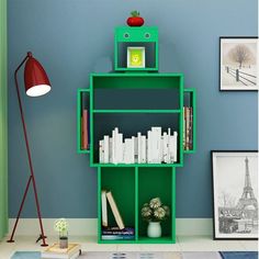 a green book shelf with books on it in a room next to a blue wall