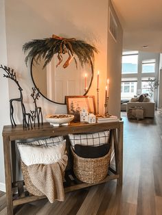 a living room filled with furniture next to a wooden table covered in pillows and blankets