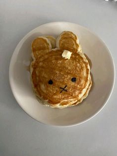 a white plate topped with pancakes and a teddy bear face