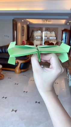 a person holding an origami airplane in their hand