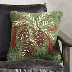 a green and red pillow sitting on top of a black chair