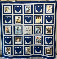 a blue and white quilt with pictures of people on it, hanging from the wall