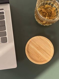 an open laptop computer sitting on top of a desk next to a cup of tea