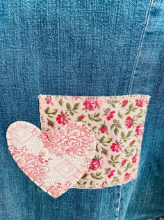 two pieces of fabric in the back pocket of a jean jacket with pink and green flowers on them