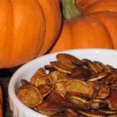 a white bowl filled with lots of pumpkins