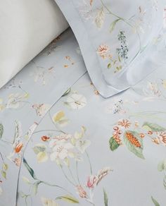 an image of a bed with flowers on the sheets and pillow cases that are not made