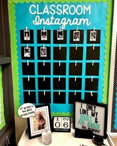 a classroom bulletin board with pictures and magnets on it, next to a small table