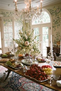 a dining room table is set with fruit and candles for a festive dinner party