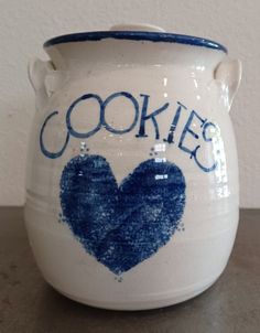 a cookie jar with the word cookies written on it and a heart painted in blue