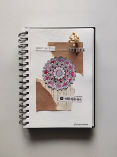 an open notebook with paper and stickers on the pages that have been altered to look like a flower