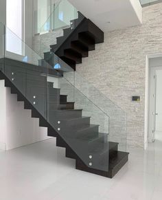 a black and white stair case with glass railing