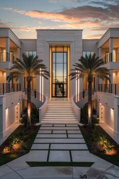 the front entrance to an apartment building with palm trees and stairs leading up to it