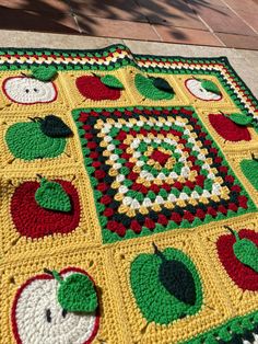 a crocheted blanket with apples on it