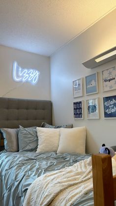 a bed sitting in a bedroom under a neon sign