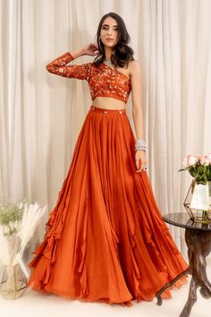 Rust orange one shoulder blouse with all-over floral embroidery. Paired with 
Component: 2
Embroidered
Neckline: One Shoulder
Sleeve Length: Asymmetric
Fabric: Tulle Net, Georgette, Shantoon
Color: Orange
Frill panel lehenga
Blouse: Concealed zip at the side - Aza Fashions Lehenga With Net Frill, Orange Sangeet Outfit, One Shoulder Lengha Blouse, One Shoulder Indian Blouse, Orange Theme Outfit, Burnt Orange Lengha, Frill Lehenga Designs, One Shoulder Blouse Designs, Desi Fusion Outfits