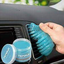 a person is cleaning the dashboard of a car with a blue scrubber and sponge