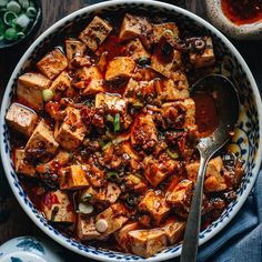 tofu in a blue and white bowl with chopsticks