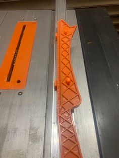 an orange piece of plastic sitting on top of a metal door frame next to a pair of scissors