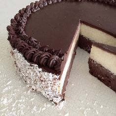 a chocolate and white cake with one slice cut out on the side, ready to be eaten