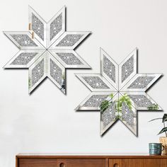 three snowflakes are hanging on the wall above a dresser