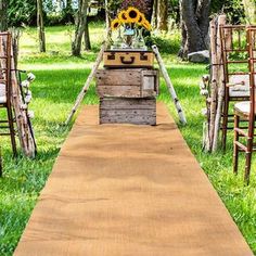 an outdoor ceremony set up with wooden chairs and sunflowers on the back ground