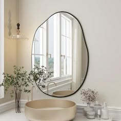 a bathroom with a sink, mirror and vases on the counter in front of it