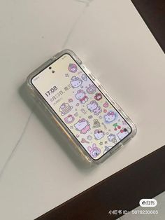 an iphone case with hello kitty stickers on the front and back cover is sitting on a table