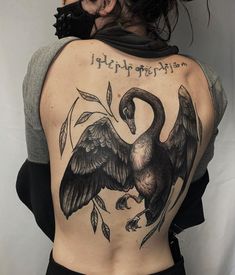 the back of a woman's body with an image of two birds on it