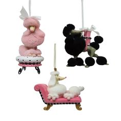 three ornaments in the shape of poodles hanging from strings