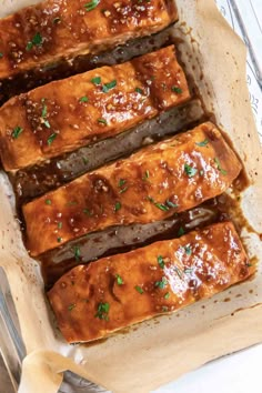 four slices of meat covered in gravy and garnished with parsley