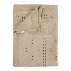 a beige blanket with holes on it