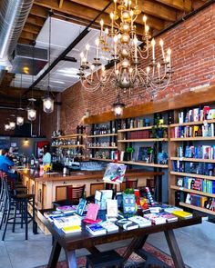 the inside of a restaurant with tables, chairs and bookshelves filled with books