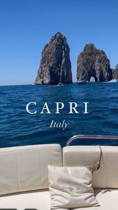 the back end of a boat with two rocks in the background and text that reads capri italy