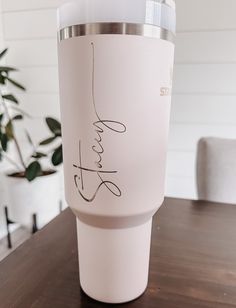 a white coffee cup sitting on top of a wooden table