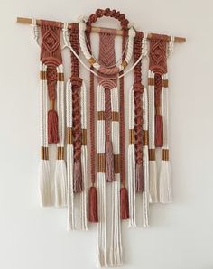 an orange and white wall hanging with some tassels on it's sides