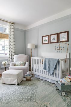 a baby's room with a crib, chair and ottoman