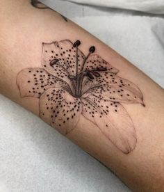 a black and white photo of a flower on the left arm, with dots all over it